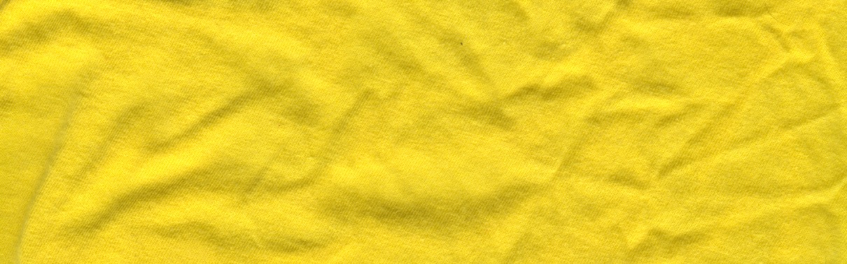 A piece of yellow fabric with a soft, velvet-like pile. The top and sides are straight lines. The bottom is an undulating curve.