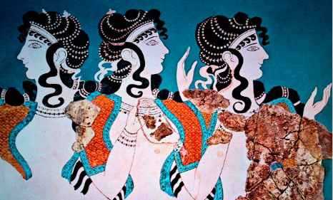 The Three Mothers as women with elaborate hairstyles in front of a blue background. Two of them look to the right. The third looks to the left. They are seen from the waist up.
